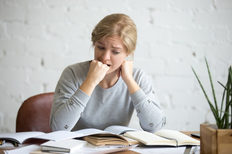 ragazza angosciata davanti ai libri 