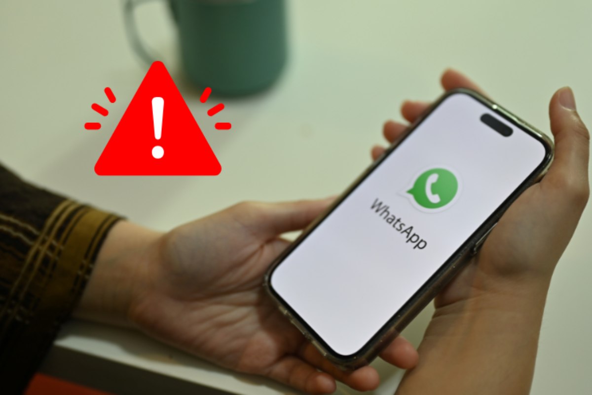persona che usa whatsapp e simbolo pericolo