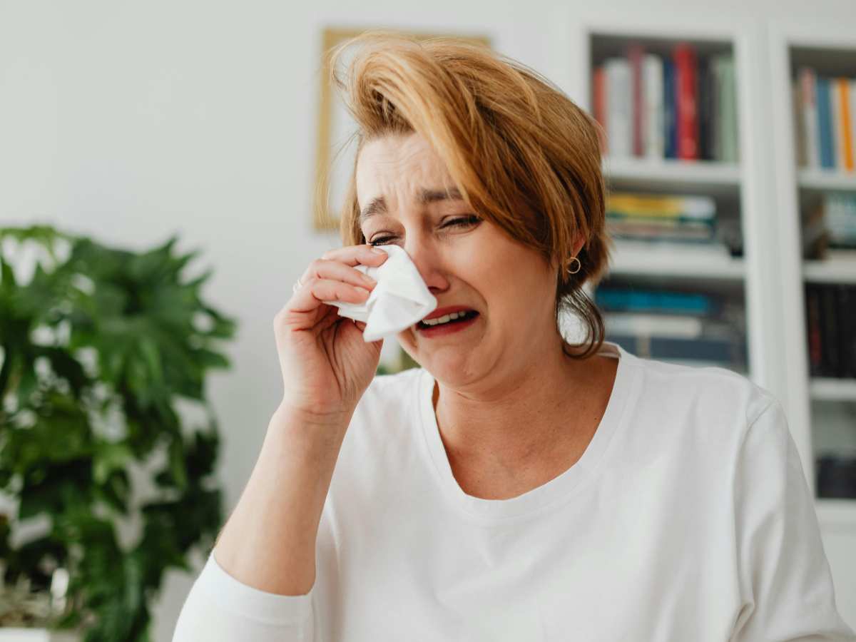 donna che piange e si asciuga gli occhi con un fazzoletto