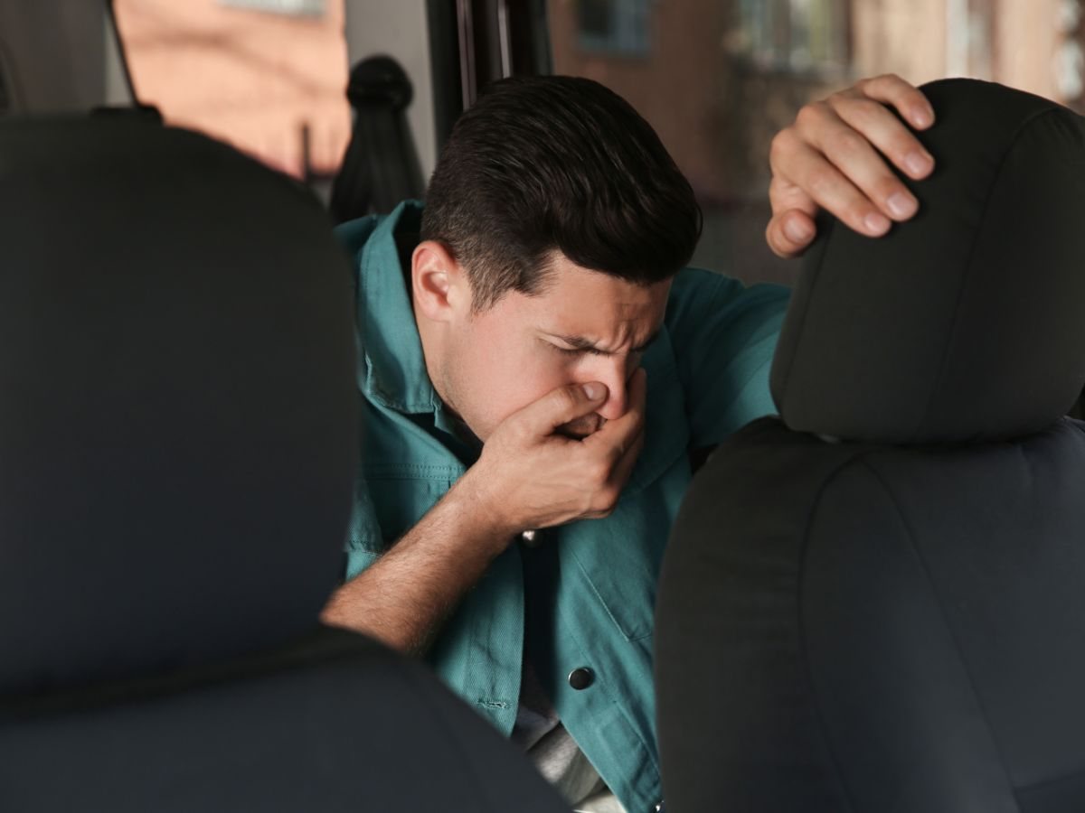 uomo che soffre di nausea in auto