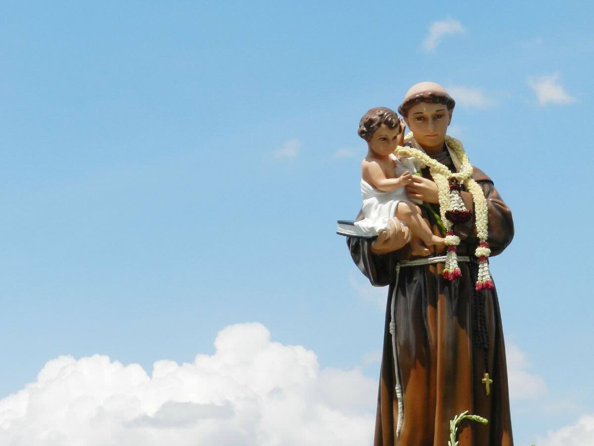 Statua di Sant'Antonio con bambinesco su sfondo il cielo azzurro