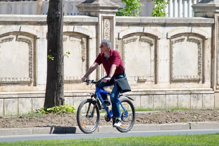 Uomo in sella a una bici per strada 